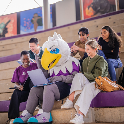 NWU Eagi working on a laptop surrounded by students